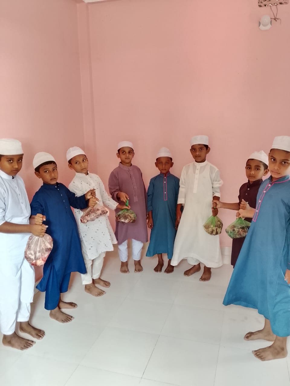 Children holding meat packages distributed through Mother Ayesha Foundation's Eid-ul-Adha Qurbani program.