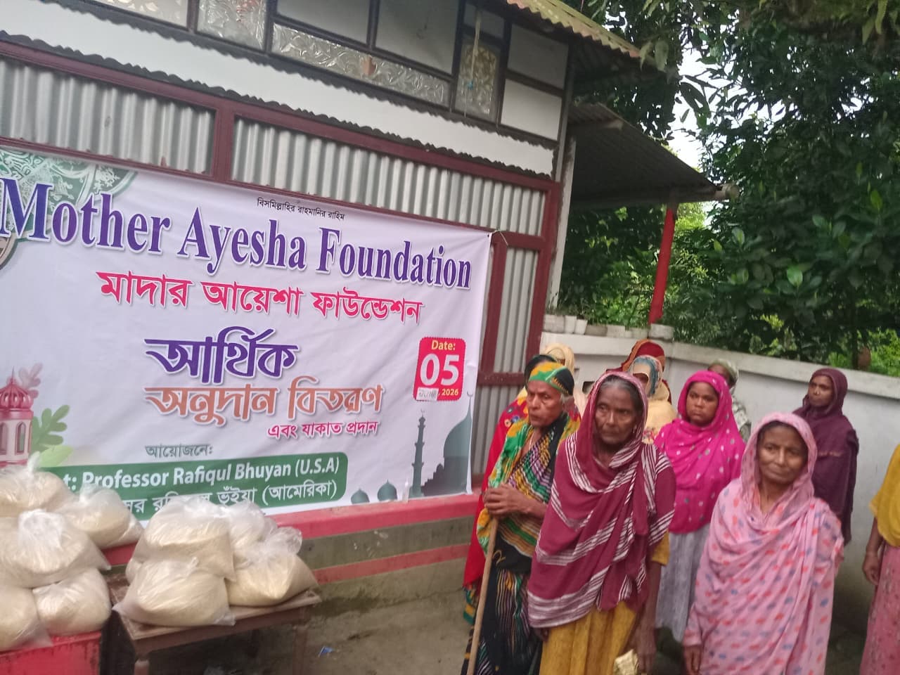 Giving away food to elderly women from the village at Mother Ayesha Foundation's financial aid and zakat distribution event on June, 2026