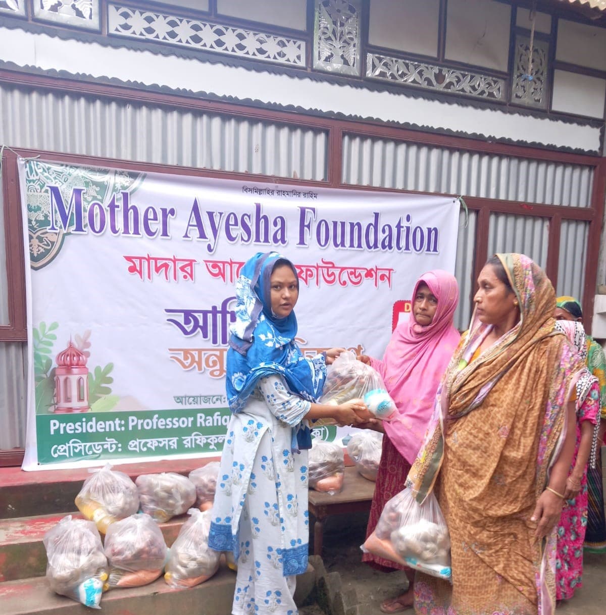 Woman receiving a food assistance package during a Mother Ayesha Foundation distribution Program